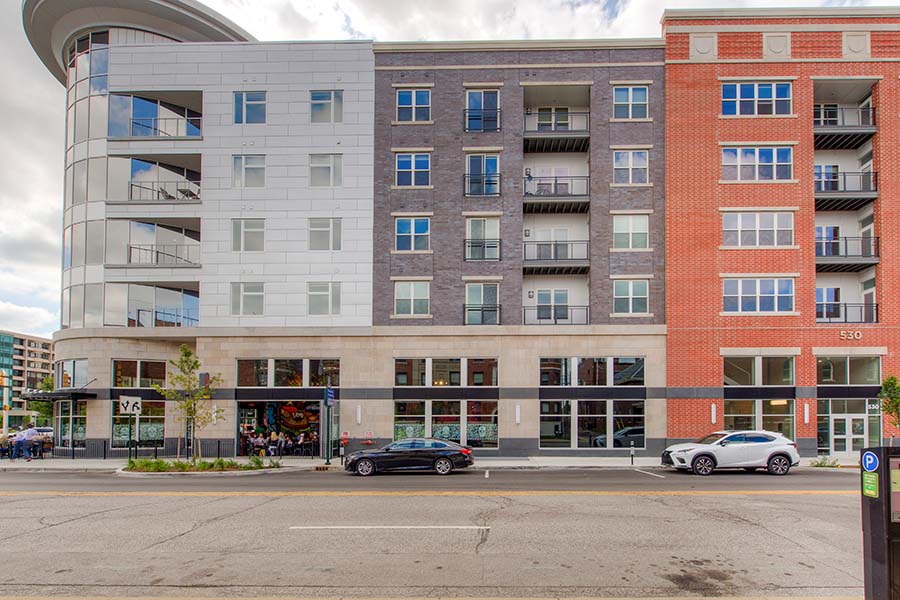 Lock your doors for security whether living in the suburbs or a downtown apartment like the Penrose on Mass Apartments. Exterior view of high-rise Penrose On Mass Apartments with cars parked in front.
