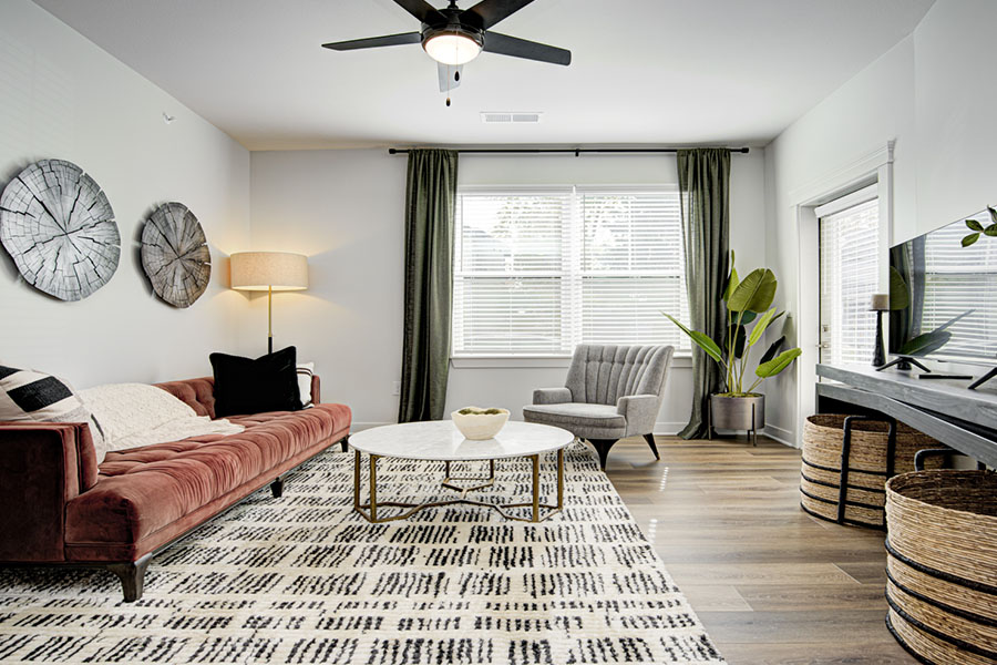 The furnishings you choose can help reflect light and make a space feel more cheerful like this unit at East Bank Apartments in Noblesville. Apartment with large, well-lit living room
