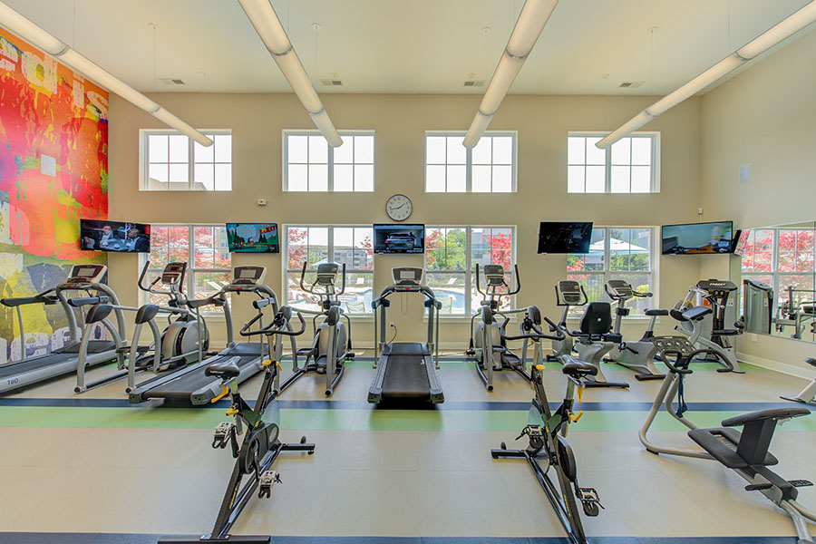 Well-lit fitness center with treadmills and stationary bikes