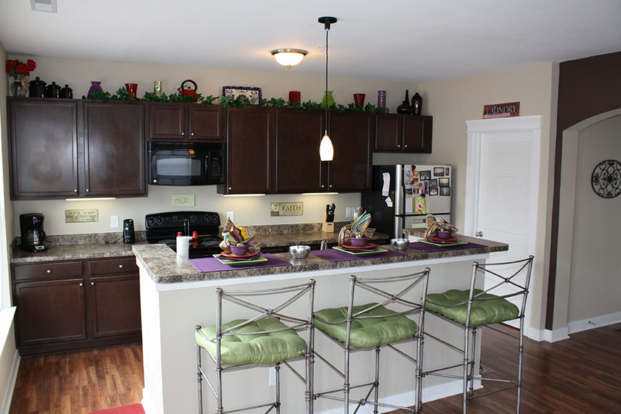 An open kitchen like this one at The Legacy Towns and Flats is perfect for you and your roommates. Kitchen with breakfast bar and chairs